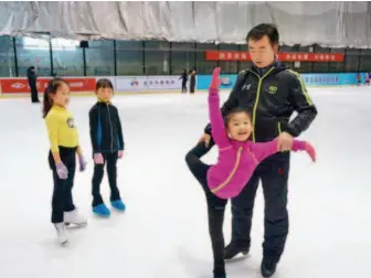  ??  ?? Figure skating coach Zhao Yang teaches primary-school students. by Feng Jin