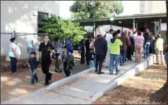  ?? NEWS-SENTINEL PHOTOGRAPH­S BY MIKE BUSH ?? A parent escorts her children while other parents wait to pick up children after Needham School was locked down on Monday afternoon.