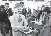  ?? TAN QINGJU / FOR CHINA DAILY ?? Visitors watch a robot painter developed by Chinese returnee students at the 2017 China overseas talent exchange conference in Guangzhou, Guangdong province.