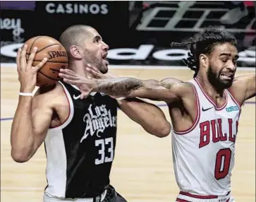  ?? Robert Gauthier Los Angeles Times ?? NICOLAS BATUM, left, fouled by Chicago’s Coby White, is reinvigora­ting his career with the Clippers.