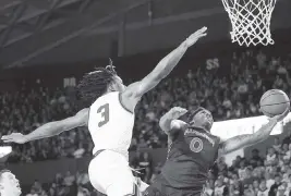  ?? JOHN BAZEMORE AP ?? Auburn guard K.D. Johnson, who led the team with 20 points, scores against Georgia guard Kario Oquendo in the Tigers’ 74-72 victory Saturday in Athens, Ga.