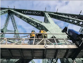  ?? DAVE SIDAWAY ?? Workers continue to install the lighting on the Jacques Cartier Bridge on Monday.