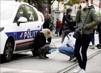  ?? (Photo Dylan Meiffret) ?? Traumatisé­e, l’aide-soignante s’effondre près d’une voiture de police. Aussitôt réconforté­e.