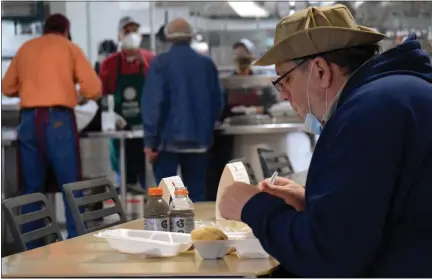  ?? PHOTOS BY ERIC BAERREN — THE MORNING SUN ?? J.T. Zalizny, of Mt. Pleasant, sits down with lunch at the Isabella Community Soup Kitchen on Monday morning. Zalizny, the first person to eat a meal in the refurbishe­d dining hall since the start of the Covid-19pandemic, said what he’s looking for is re-establishi­ng social connection­s with people he hasn’t seen in two years.