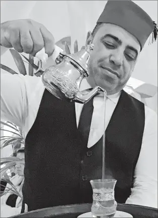  ?? FRANCOISE DROGIN/LOS ANGELES TIMES ?? A waiter pours sweet mint tea after dinner at Rick's Cafe in Casablanca.