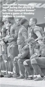  ??  ?? Jacksonvil­le Jaguars players kneel during the playing of the “Star-Spangled Banner” before a game at Wembley Stadium in London.