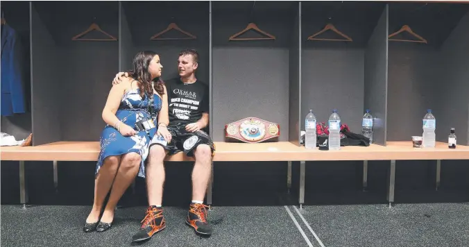  ?? CHAMPION: Jeff Horn sits with wife Jo and has a quiet moment after his amazing victory at Suncorp Stadium, with the WBO welterweig­ht belt by his side. Picture: PETER WALLIS ??