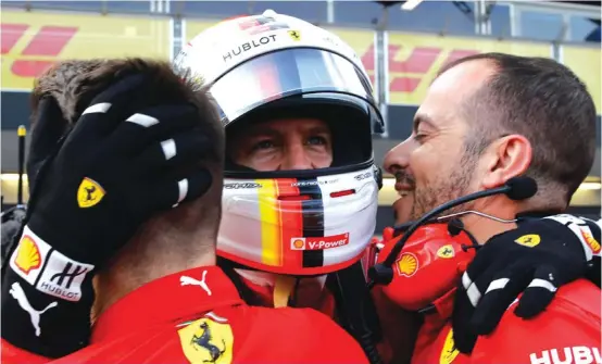  ??  ?? Ferrari driver Sebastian Vettel of Germany celebrates with team members after he clocked the fastest time in the qualifying session at the Baku Formula One city circuit Photo: AP