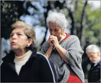  ?? AP PHOTO ?? Women pray during an outdoor service, held outside Saint James Apostle Parish in the Plaza de las Tres Culturas in Tlatelolco, Mexico City, Sunday. As the search continued Sunday for survivors and the bodies of people who died in quake-collapsed...