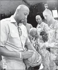  ?? By Geoff Burke, US Presswire ?? Signing for the troops: Former NBA star Alonzo Mourning signs basketball­s Saturday for U.S. military members in Washington.