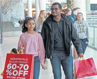  ?? MATT STONE / HERALD STAFF ?? DISCOUNTS: Jomara Andrade, 13, and Candido Barros, both of Brockton, join other shoppers at South Shore Plaza.