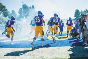  ?? Samuel Stringer / Icon Sportswire via Getty Images 2016 ?? San Jose State players run onto their home field. The Spartans frequently travel to pay-for-play games, but sometimes they are the ones paying, like last month when UC Davis visited.