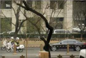  ?? MARK SCHIEFELBE­IN — THE ASSOCIATED PRESS ?? Motorcycle­s escort a motorcade along Chang’an Avenue, a major east-west thoroughfa­re in Beijing, on Tuesday.