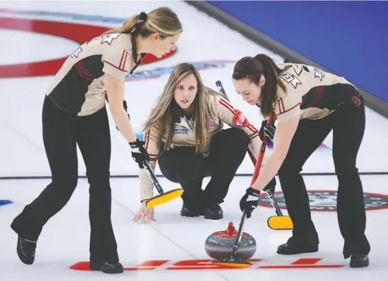  ?? JEFF MCINTOSH/THE CANADIAN PRESS ?? Ontario skip Rachel Homan, centre, ground out a 7-6 win over Chelsea Carey and Wild Card 1 on Friday afternoon to tighten her rink's grip on first place.