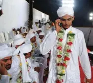  ?? SAJJAD HUSSAIN/AFP/GETTY IMAGES ?? Indian Muslim bridegroom­s clad in white.