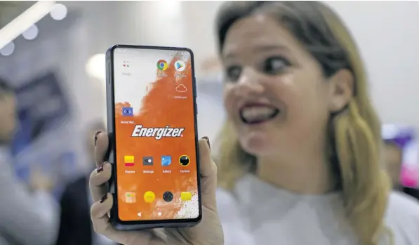  ??  ?? BIG BATTERY: A worker holds a new model of the Energizer Power Max P18K Pop at the Mobile World Congress wireless show in Barcelona.