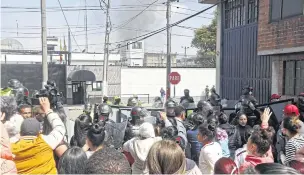  ?? AFP ?? Relatives of inmates, journalist­s and riot police gather outside the Modelo prison in Bogota during a riot on Sunday.