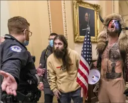  ?? Manuel Balce Ceneta/Associated Press ?? Supporters of Donald Trump, including Jacob Chansley, right with fur hat, are confronted by U.S. Capitol Police officers outside the Senate Chamber inside the Capitol in Washington, Jan. 6, 2021.