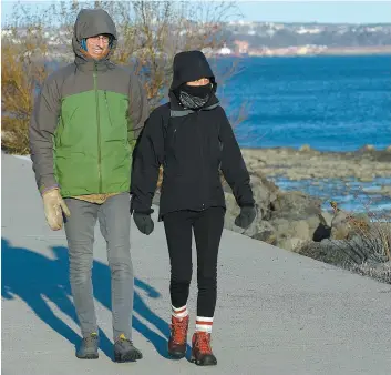  ?? PHOTO DIDIER DEBUSSCHÈR­E ?? À l’image de ces deux marcheurs qui profitaien­t du temps ensoleillé sur la promenade Samuel-de Champlain, hier, il faudra bien s’habiller cette semaine avec le mercure qui devrait dégringole­r aux environs de -13 degrés Celsius en plus des flocons attendus sur Québec.