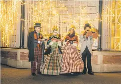  ??  ?? Carollers roam at the Bronx Zoo’s Holiday Lights display.