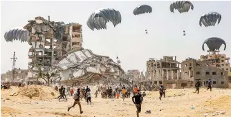  ?? AFP-Yonhap ?? People rush toward humanitari­an aid packages dropped over the northern Gaza Strip, Tuesday.