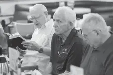  ?? NWA Democrat-Gazette/DAVID GOTTSCHALK ?? Jim Johnston (left) reads scripture during the men’s breakfast. The group meets at 6:30 a.m. every Wednesday.