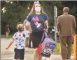  ?? Brian A. Pounds / Hearst Connecticu­t Media ?? Principal Amy Cosciello walks a student into school during first day drop off at Mead School in Ansonia on Thursday.