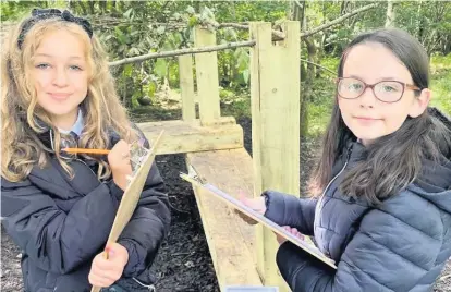  ??  ?? Taking notes Pupils Freya Mcauley (left) and Ellie Broadie identify leaf species