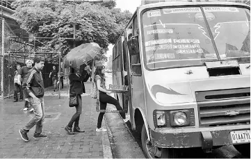  ??  ?? Above left, Blanco (left), Fernandez (centre) and Mejias board a bus to give a presentati­on of the Bus TV news in Caracas, Venezuela, on June 6. • Blanco (left), Castillo (centre-1), Fernandez (centre-2) and Mejias (right) walk to a bus stop to give an...