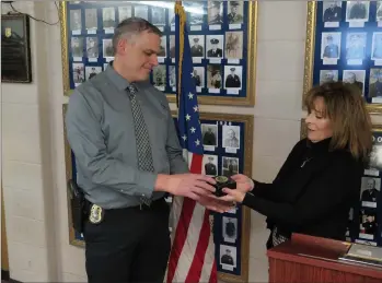  ??  ?? Woonsocket Police Lt. Normand Galipeau, left, received special recognitio­n as the department’s accreditat­ion coordinato­r, here receiving an award from Christine Crocker, the commission’s executive director.