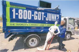  ?? DAMIAN DOVARGANES/ASSOCIATED PRESS ?? Franchisee James WIlliams loads a store mannequin into a truck in Burbank, Calif. Williams’ business, 1-800-GOT-JUNK?, empties out closed chain stores and hauls away the fixtures and contents.