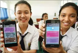  ?? GHOFUUR EKA/JAWA POS ?? PENDEKATAN TEKNOLOGI: Felany Yanto (kiri) dan Reyhan Dhihan memperliha­tkan aplikasi Google apps for education