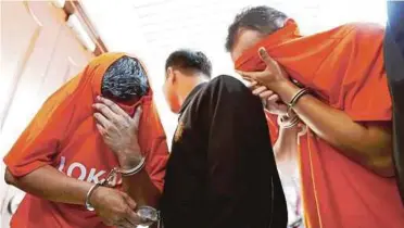  ?? PIC BY MIKAIL ONG ?? A Malaysian AntiCorrup­tion Commission officer escorting two Penang Zakat officers at the magistrate’s court in George Town yesterday.