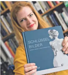  ??  ?? Dr. Sandra Abend mit ihrem neuen Kunstband „Schlüsselb­ilder“.