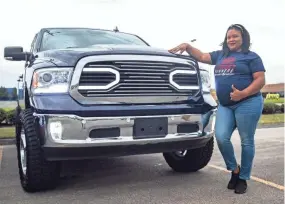  ??  ?? Tameca Mcpherson stands next to her 2018 RAM 1500 truck equipped with a 5.7 hemi engine on April 7. She is a member of Street Runners.