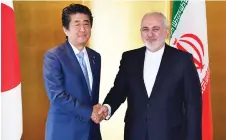  ?? — AFP photo ?? Abe (left) greets Zarif during their bilateral meeting in Yokohama.