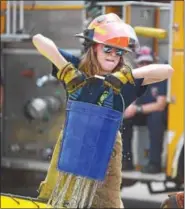  ?? PETE BANNAN — DIGITAL FIRST MEDIA ?? Hannah Matlack of the Glen Moore Fire company takes part in the bucket brigade component of Chester County Department of Emergency Services’ Junior Public Safety Camp Olympics Thursday at the Chester County Public Safety Training Campus, Tactical...