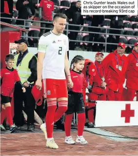  ??  ?? Chris Gunter leads Wales out as skipper on the occasion of his record-breaking 93rd cap