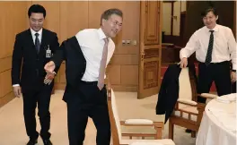  ?? — AP ?? South Korean President Moon Jae-in takes off his jacket at the presidenti­al Blue House in Seoul on Thursday. South Korean Internet users have shared photos of Moon waving off a presidenti­al employee and taking off his own jacket at a luncheon...