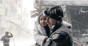  ?? /AFP ?? Lives threatened: A member of the White Helmets volunteers carries a wounded girl in this file photograph. The organisati­on is a network of first responders who rescue wounded civilians in the aftermath of air strikes, shelling or blasts in rebel-held...