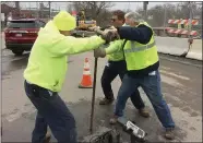  ?? EVAN BRANDT — MEDIANEWS GROUP ?? Borough workers, including Public Works Director Doug Yerger, at right, struggle to close a valve to allow repairs on a broken water main to get underway Wednesday.