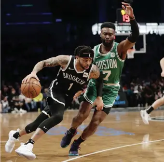  ?? ASSOCIATED PRESS ?? TURNING THE CORNER: Jaylen Brown defends as the Nets’ D'Angelo Russell drives to the hoop during the first half last night in New York.