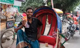 ?? Hossen/The Guardian ?? Jewel Ahmed, with his bun roti at the roadside in Zigatola, Dhaka. Photograph: Farzana