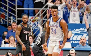  ?? Colin E Braley/Associated Press ?? Kansas forward KJ Adams Jr., right, reacts after scoring as Houston’s Jamal Shead looks on during the second half on Saturday. Adams scored 10 points.