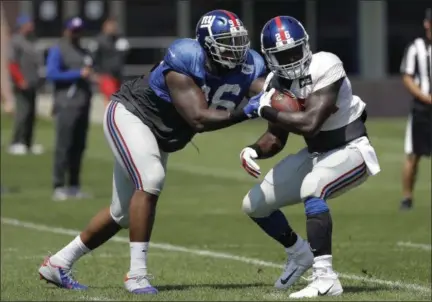  ?? AP FILE ?? Giants defensive tackle Jay Bromley, left, grabs at running back Orleans Darkwa during recent training camp in East Rutherford, N.J.