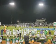  ?? LESLIE GAMBONI/ASSOCIATED PRESS FILE PHOTO ?? Isidore Newman High School’s football team and cheerleade­rs during a Nov. 20 game at South Plaquemine­s High School in Buras, La. Repeated hurricanes have devastated the state’s schools, teams and athletic fields.