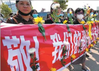  ?? YIN GANG / FOR CHINA DAILY ?? People outside a funeral house in Xichang, Sichuan province, on Tuesday bid farewell to 19 firefighte­rs who died earlier while trying to put out a forest blaze.