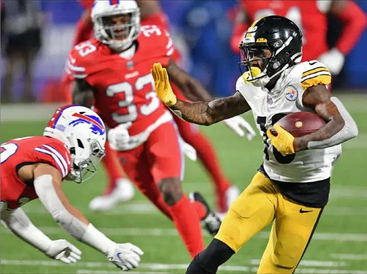  ?? Peter Diana/Post-Gazette ?? Steelers wide receiver Diontae Johnson picks up yardage but had a disappoint­ing game as drops continued to plague him. Coach Mike Tomlin benched him in the first half.