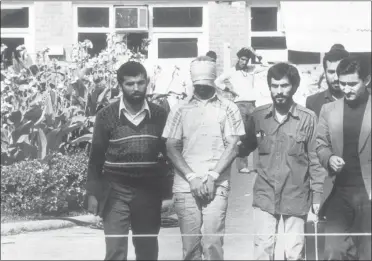  ?? STR—ASSOCIATED PRESS ?? In this Nov. 8, 1979file photo, one of the hostages held at the U.S. Embassy in Tehran, Iran is shown to the crowd by Iranian students. Forty years ago on Nov. 4, 1979, Iranian students overran guards to take over the U.S. Embassy in Tehran, starting a 444-day hostage crisis that transfixed America.