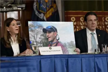  ?? Hans Pennink/Associated Press ?? Linda Beigel Schulman, left, holds a photograph of her son Scott Beigel, who was killed during the Valentine’s Day massacre at Marjory Stoneman Douglas High School, while speaking with New York Gov. Andrew Cuomo and gun safety advocates during a news conference Jan. 29 at the state Capitol in Albany, N.Y.